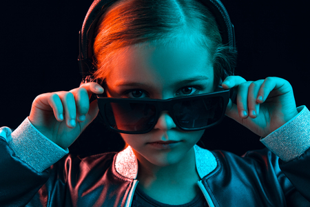 Neon portrait of young girl with headphones enjoying music. Lifestyle of young people, human emotions, childhood, happiness concept.の写真素材