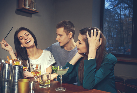Photo of joyful friends in the bar or at pub communicating with each otherの写真素材