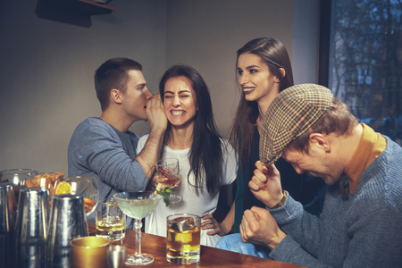 Photo of joyful friends in the bar or at pub communicating with each otherの写真素材