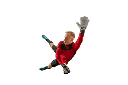 Male soccer player goalkeeper catching ball in jump. Silhouette of fit man with ball isolated on white studio backgroundの写真素材