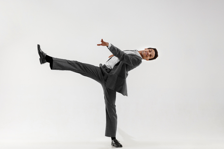 Happy businessman dancing in motion isolated on white studio background. Flexibility and grace in business. Human emotions concept. Office, success, professional, happiness, expression conceptsの写真素材