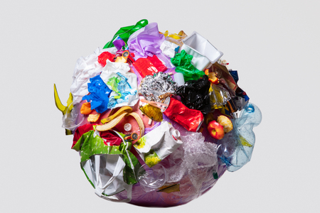 A globe of the earth with trash over white background, the concept of ecology problem and World Environment Day. Photo with message for social advertising, place for inscriptionの写真素材