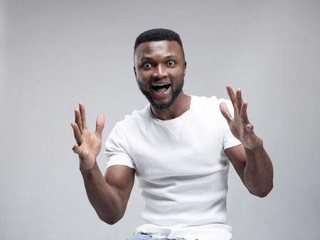 I won. Winning success happy man celebrating being a winner. Dynamic image of african male model on gray studio background. Victory, delight concept. Human facial emotions conceptの写真素材