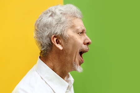 Screaming, hate, rage. Crying emotional angry man screaming on studio background. Emotional senior face. male half-length portrait. Human emotions, facial expression concept. Trendy colorsの写真素材