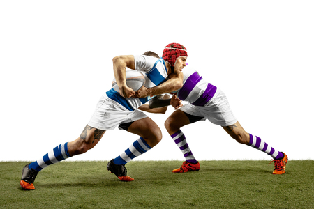The silhouette of two caucasian rugby male players isolated on white background. Studio shot of fit men in motion or movement with ball. Jump and action concept. An incredible strain of all forces.の写真素材
