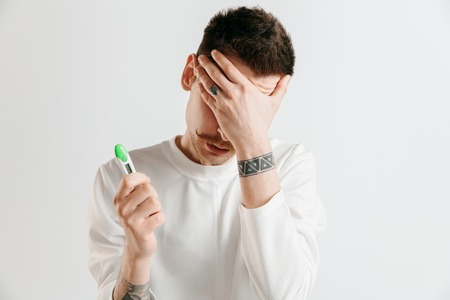 Upset man looking in pregnancy test. Human emotions conceptの写真素材