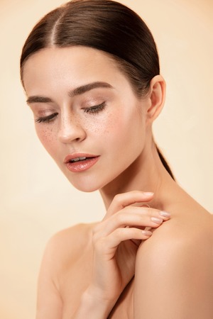 A beautiful female face. Perfect and clean skin of young caucasian woman on pastel studio background.の写真素材