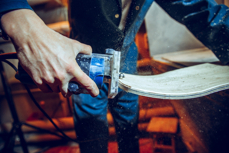 Carpenter using circular saw for cutting wooden boards. Construction details of male worker or handy man with power toolsの写真素材
