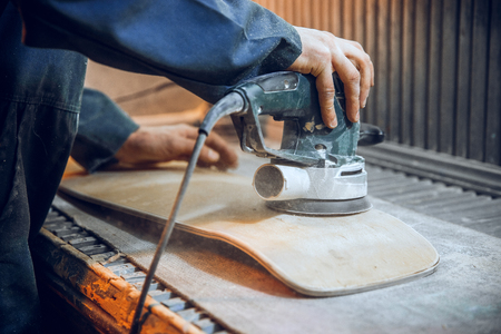 Carpenter using circular saw for cutting wooden boards. Construction details of male worker or handy man with power toolsの写真素材