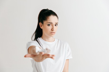 Young woman with a surprised unhappy expression lost a bet on studio background. Human facial...