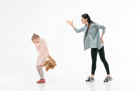 Angry mother scolding her daughter at home. Studio shot of emotional family. Human emotions,...