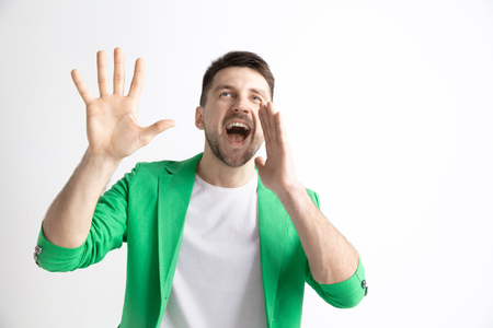 Young casual man shouting. Shout. Crying emotional man screaming on studio background. male half-length portrait. Human emotions, facial expression concept.の写真素材