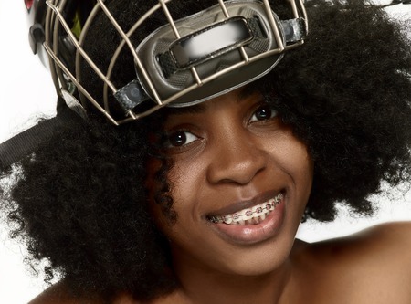 Female hockey player close up helmet and mask over white studio background. African american modelの写真素材