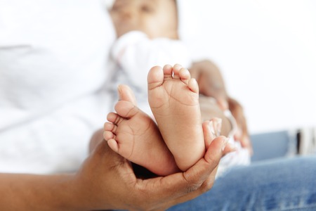 Closeup portrait of beautiful african woman holding on hands her little daughter on white background. Family, love, lifestyle, motherhood and tender moments concepts. Mothers day concept or backgroundの写真素材