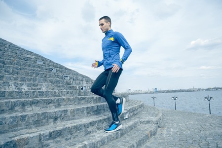 Man running on city background at morning. Healthy lifestyle concept.の写真素材