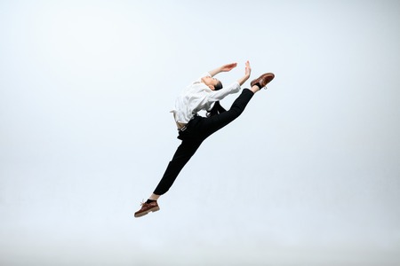 Inspiration of self-development. Happy woman working at office, jumping and dancing in casual clothes or suit isolated on white studio background. Business, start-up, working open-space concept.の写真素材