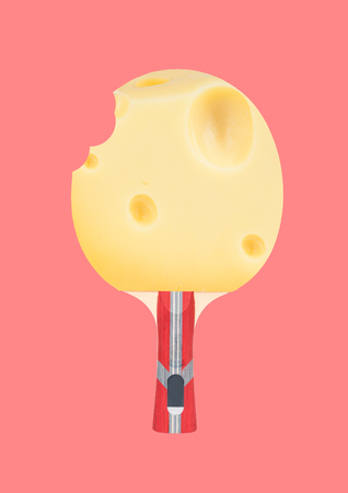 An alternative view of healthy food. Tennis racket with the plate as a holland cheese against trendy coral background. Modern design. Contemporary art collage. Concept of sport, lunch, breakfest.の写真素材