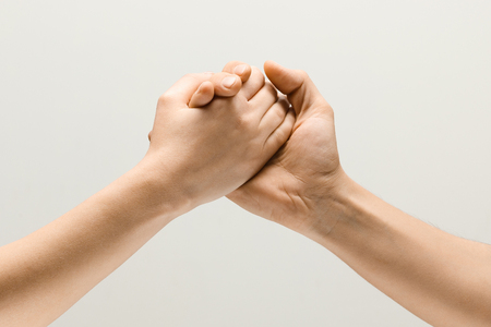Dont fight, lets be friends. Two male hands competion in arm wrestling isolated on grey studio background. Concept of standoff, support, friendship, business, community or strained relations.の写真素材