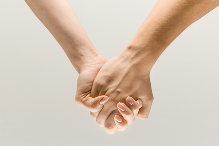 Leading you on. loseup shot of male and female holding hands isolated on grey studio background. Concept of human relations, friendship, partnership, family. Copyspace.の写真素材