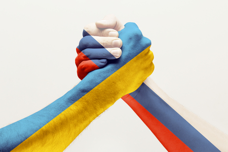 Stop to find out whos better. Two male hands fighting colored in Russia and Ukraine flags isolated on white studio background. Concept of political, economical, social aggressions, disagreement.の写真素材