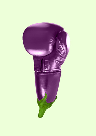 An alternative sport or hematoma. A boxing glove as an eggplant on green background. Negative space to insert your text. Modern design. Contemporary art collage. Concept of food, movement, plants.の写真素材