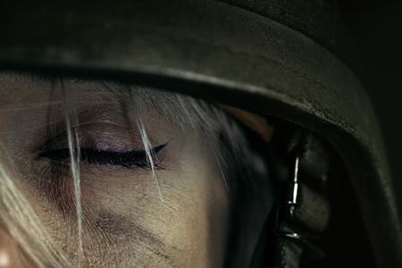 Have no sweet dreams at night, but nightmares. Close up portrait of young female soldier. Woman in military uniform on the war. Depressed and having problems with mental health and emotions, PTSD.の写真素材