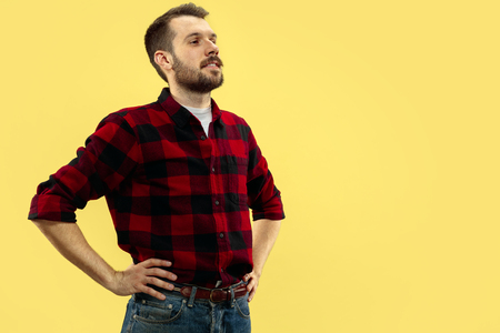 Half-length close up portrait of young man in shirt on yellow background. The human emotions, facial expression concept. Front view. Trendy colors. Negative space. Standing and smiling.の写真素材