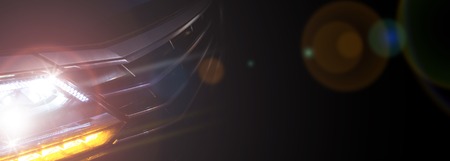 Headlight of a modern car in dense fog against dark background. Exterior details and beauty of...