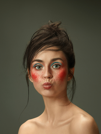 Sending kisses. Beautiful female face with perfect skin and bright make up. Concept of natural beauty, skin care, treatment, health, spa, cosmetic. A creative artistic stage act, signature character.の写真素材