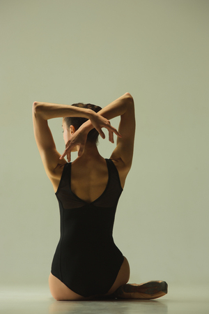 Graceful ballet dancer or classic ballerina dancing isolated on grey studio background. Showing flexibility and grace. The dance, artist, contemporary, movement, action and motion concept.の写真素材