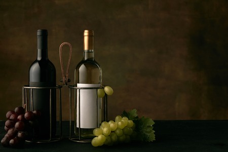 Front view of tasty fruit plate of grapes with the wine bottles on dark studio background, copy space to insert your text or image. Gourmet food and drink.の写真素材