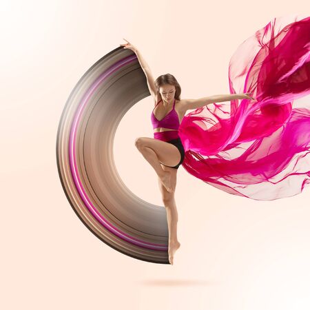 Graceful ballet dancer or classic ballerina dancing isolated on studio background. Woman dancing with pink silk cloth. The dance, grace, artist, contemporary, movement concept. Abstract design.の写真素材