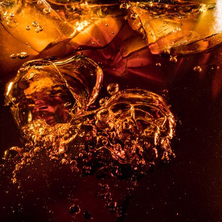 Close up view of the ice cubes in dark fizzy drinkの写真素材