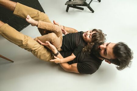 Father playing with young son in their sitting room at home. Young dad having fun with his children...