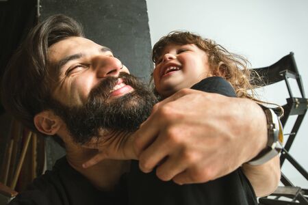 Father playing with young son in their sitting room at home. Young dad having fun with his children...
