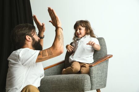 Father playing with young son in their sitting room at home. Young dad having fun with his children...
