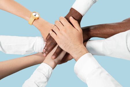 To be a good team. Teamwork and communications. Male and female hands holding isolated on blue...