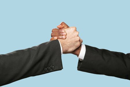 Sign of joint plans for the future. Teamwork and communications. Two male hands shaking isolated on...