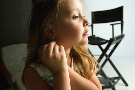Interaction of children with adult world. Cute girl wearing accessories for being older, looking playful, happy. Little female model trying on mums jewelry at home. Childhood, style, dream concept.の写真素材