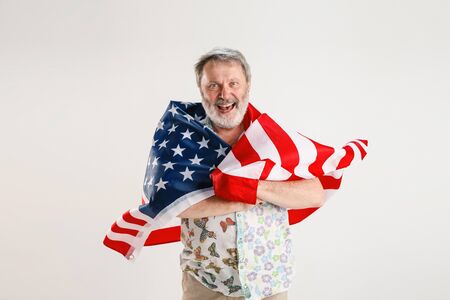 Celebrating an Independence day. Stars and Stripes. Senior man with the flag of the United States of...