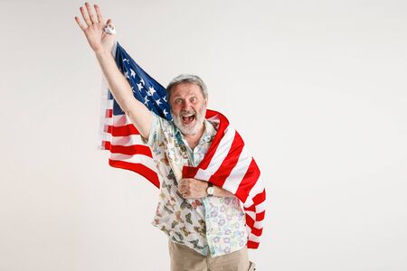 Celebrating an Independence day. Stars and Stripes. Senior man with the flag of the United States of...