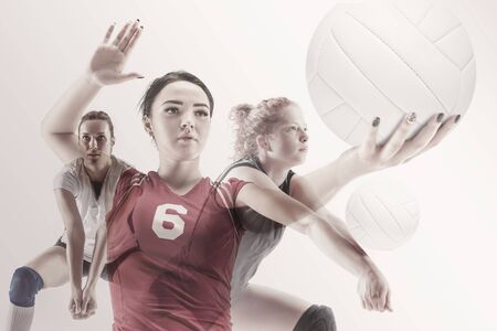 Young female volleyball player isolated on white studio background. Woman in sports equipment and shoes or sneakers training and practicing. Concept of sport, healthy lifestyle, motion and movement.の写真素材