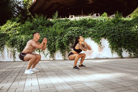 A muscular athletes doing workout at the park. Gymnastics, training, fitness workout flexibility....