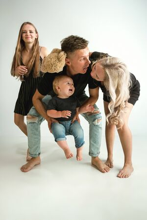 Happy father holding adorable little son and smiling at camera. Young parents playing with son and...