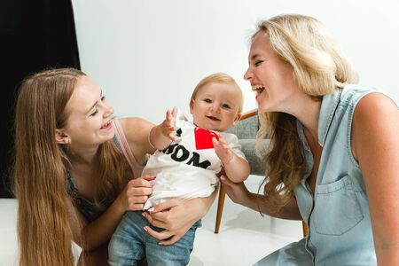 Young family spending time together and smiling. Mom with young daughter and little son playing and...