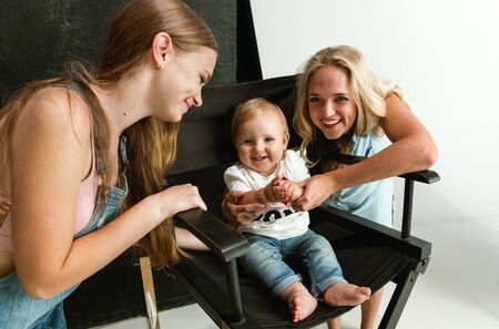 Young family spending time together and smiling. Mom with young daughter and little son playing and...