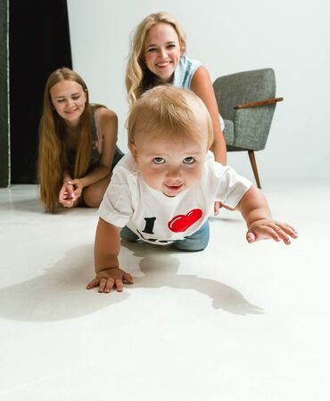 Young family spending time together and smiling. Mom with young daughter and little son playing and...