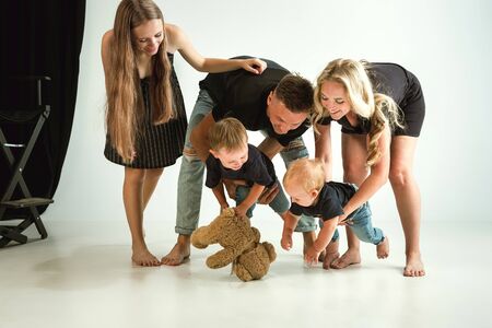 Young family spending time together and smiling. Parents with young daughter and little sons playing and laughting. Family lifestyle. Mothers, fathers day, togetherness, parenthood, kids rights concept.の写真素材