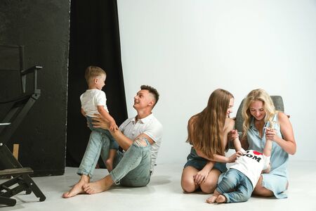 Young family spending time together and smiling. Parents with young daughter and little sons playing and laughting. Family lifestyle. Mothers, fathers day, togetherness, parenthood, kids rights concept.の写真素材