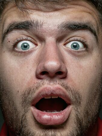 Close up portrait of young and emotional caucasian man. Highly detail photoshot of male model with well-kept skin and bright facial expression. Concept of human emotions. Shocked and astonished.の写真素材